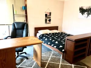 a bedroom with a bed and a desk and a chair at Budget Clayton Homestay in Clayton North