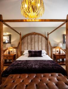 a bedroom with a large bed and a chandelier at Black Horse Beamish in Stanley