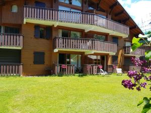 a large building with balconies and a yard at Studio Le Marquis 2 in Morzine