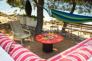 una hamaca y una mesa con bebidas en el patio en Obiteljska kuća za odmor Futura, en Milna