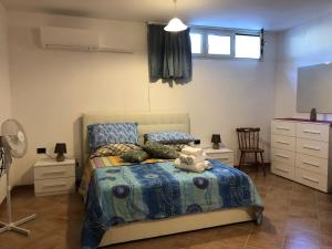 a bedroom with a bed with a blue comforter at Appartamento in Villa Andreina - Seminterrato in Orosei