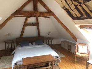 1 dormitorio con 1 cama y suelo de madera en La Maison en Les Forges