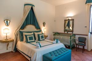 a bedroom with a large bed and a blue chair at Masseria Santo Stefano Relais&Charming House in Conversano