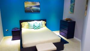 a bedroom with a bed with a blue wall at Donhead New Kingston Apt 3 in Kingston