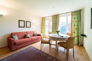 a living room with a red couch and a table at Alpinikum Apartments in Lech am Arlberg