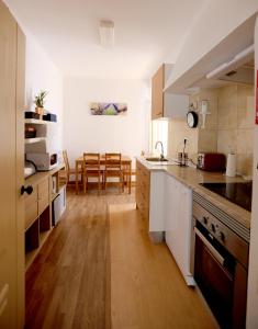 a kitchen with white cabinets and a wooden floor at Azeitão Village in Azeitao