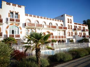 a building with a palm tree in front of it at Residence de L'Ocean in La Tranche-sur-Mer