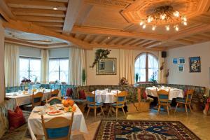 a restaurant with tables and chairs and a chandelier at Hotel-Appartement Ferienhof in Gerlos
