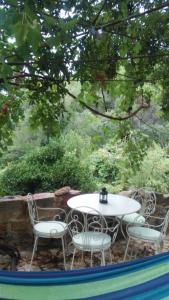 uma mesa branca e cadeiras sentadas ao lado de uma piscina em La Toscana em Linares de la Sierra