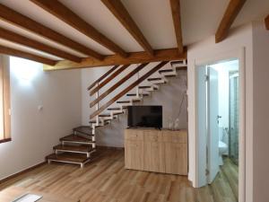 a living room with a staircase and a television at Hotel Vetrenjača in Vršac