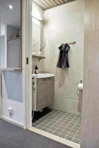 a bathroom with a shower with a sink and a toilet at RUKA2103 CHALET in Kuusamo