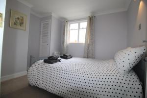 a bedroom with a bed with black and white polka dots at 1 Steam Packet Cottage in Canterbury