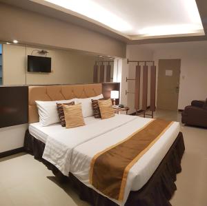 ein Schlafzimmer mit einem großen Bett in einem Zimmer in der Unterkunft North Tourist Inn in Bacolod City