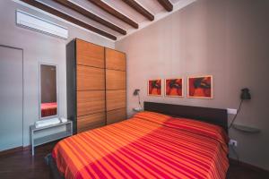 - une chambre dotée d'un lit avec une couverture rayée rouge et orange dans l'établissement Beautiful apartament 2 minute walk from Colosseum, à Rome