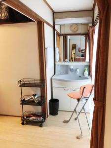 a kitchen with a table and a chair in a room at 萩ゲストハウスラビット in Hagi