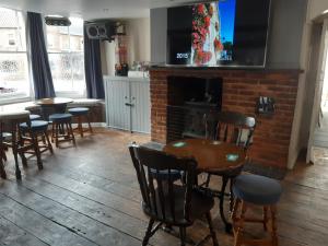 a room with tables and chairs and a fireplace at The Rampant Horse Public House in Fakenham