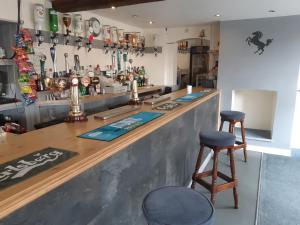 a bar with two bar stools and a counter at The Rampant Horse Public House in Fakenham