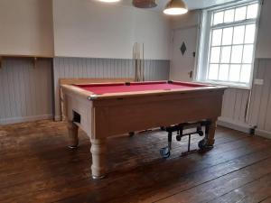 a room with a pool table on a wooden floor at The Rampant Horse Public House in Fakenham