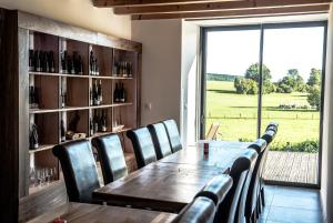 a dining room with a table and chairs and a window at ferme du bois joli in Marigny