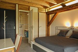 a bedroom with a bed and a desk and a shower at ferme du bois joli in Marigny