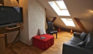 a living room with a tv and a couch and a chair at ferme du bois joli in Marigny