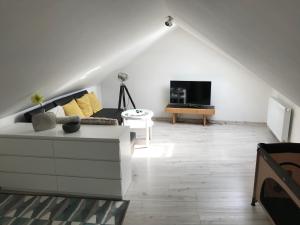 a living room with a white couch and a tv at Apartmán na náměstí in Kašperské Hory