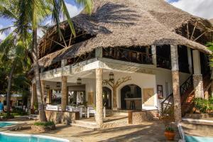 a resort with a thatched roof and a swimming pool at Aquarius Club in Watamu