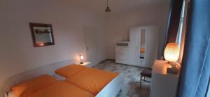 a small bedroom with an orange bed and a lamp at Ferienwohnung in der Altstadt von Goslar in Goslar