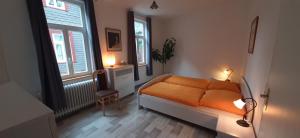 1 dormitorio con cama de color naranja y ventana en Ferienwohnung in der Altstadt von Goslar, en Goslar