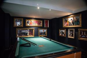 una mesa de billar en una habitación con fotos en las paredes en HOTEL BARILOCHE CITY en San Carlos de Bariloche