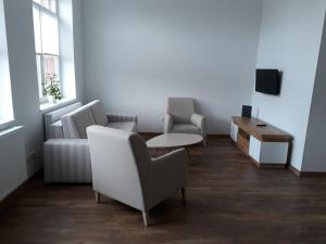 a living room with two chairs and a table and a couch at Ferienwohnung Ela in Wilhelmshaven