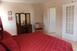 Schlafzimmer mit einem roten Bett und einem Spiegel in der Unterkunft Casa Canukatan in Chelem
