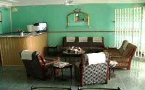 een woonkamer met een bank en een tafel en stoelen bij Sampson's Guesthouse Company Ltd. in Kwashieman
