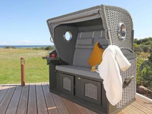 a chair sitting on a wooden deck in a vehicle at Strandhaus 7 "Ostsee" F663 mit Meerblick, Sauna, Kamin in Lobbe