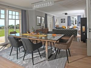 a living room with a dining room table and chairs at Strandhaus 7 "Ostsee" F663 mit Meerblick, Sauna, Kamin in Lobbe