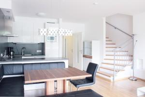 a kitchen and dining room with a wooden table at Haus CKPK Lux in Sonnenalpe Nassfeld