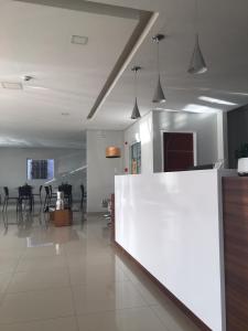 a lobby with a white counter in a room at Ilha Bela Hotel in Paulo Afonso