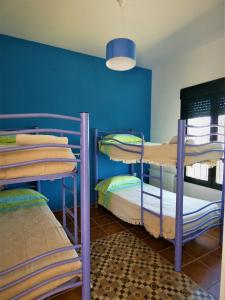 two bunk beds in a room with a blue wall at Casa Rural Brigido in Villanueva de Tapia