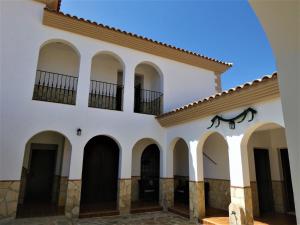 a building with arches and a horse statue on the side at Casa Rural Brigido in Villanueva de Tapia