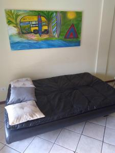 un sofá en una habitación con una pintura en la pared en Vila das Gaivotas, en Florianópolis