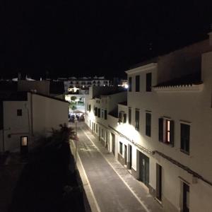 eine Stadtstraße in der Nacht mit weißen Gebäuden in der Unterkunft Cas Conco in Es Mercadal