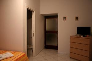 a bedroom with a bed and a dresser with a television at Diana e Atteone in Caserta