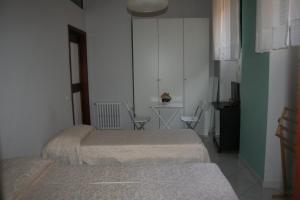 a room with two beds and a table and chairs at Diana e Atteone in Caserta