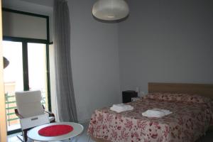 a bedroom with a bed and a chair and a window at Diana e Atteone in Caserta