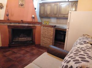 uma sala de estar com lareira e uma cozinha em Casa Rural El Tejo em Arroyo Frío
