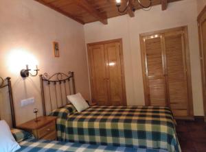 a bedroom with two beds in a room at Casa Rural El Tejo in Arroyo Frio +8 photos