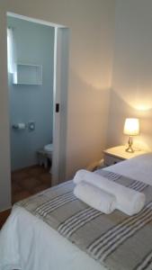 1 dormitorio con 1 cama con 2 toallas en The Loft on Lambert, en Port Alfred