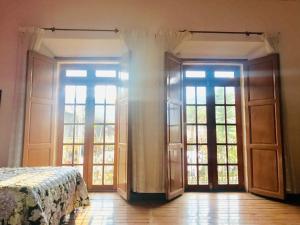 um quarto com portas e janelas e uma cama em Casa Afif em Tlatlauquitepec