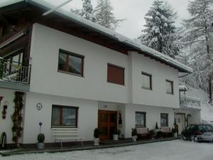 a white house with a car parked in front of it at Appartements Falkner in Roppen