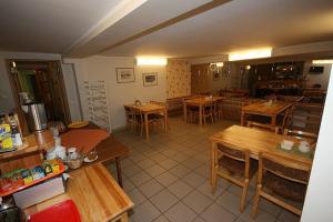 a kitchen with wooden tables and tables in a restaurant at Hotell Sõnajala in Kärdla
